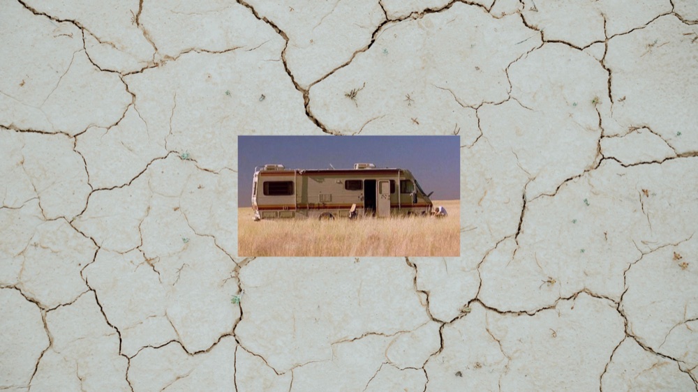 Autocaravana en un campo de hierba seca, recortada sobre tierra agrietada